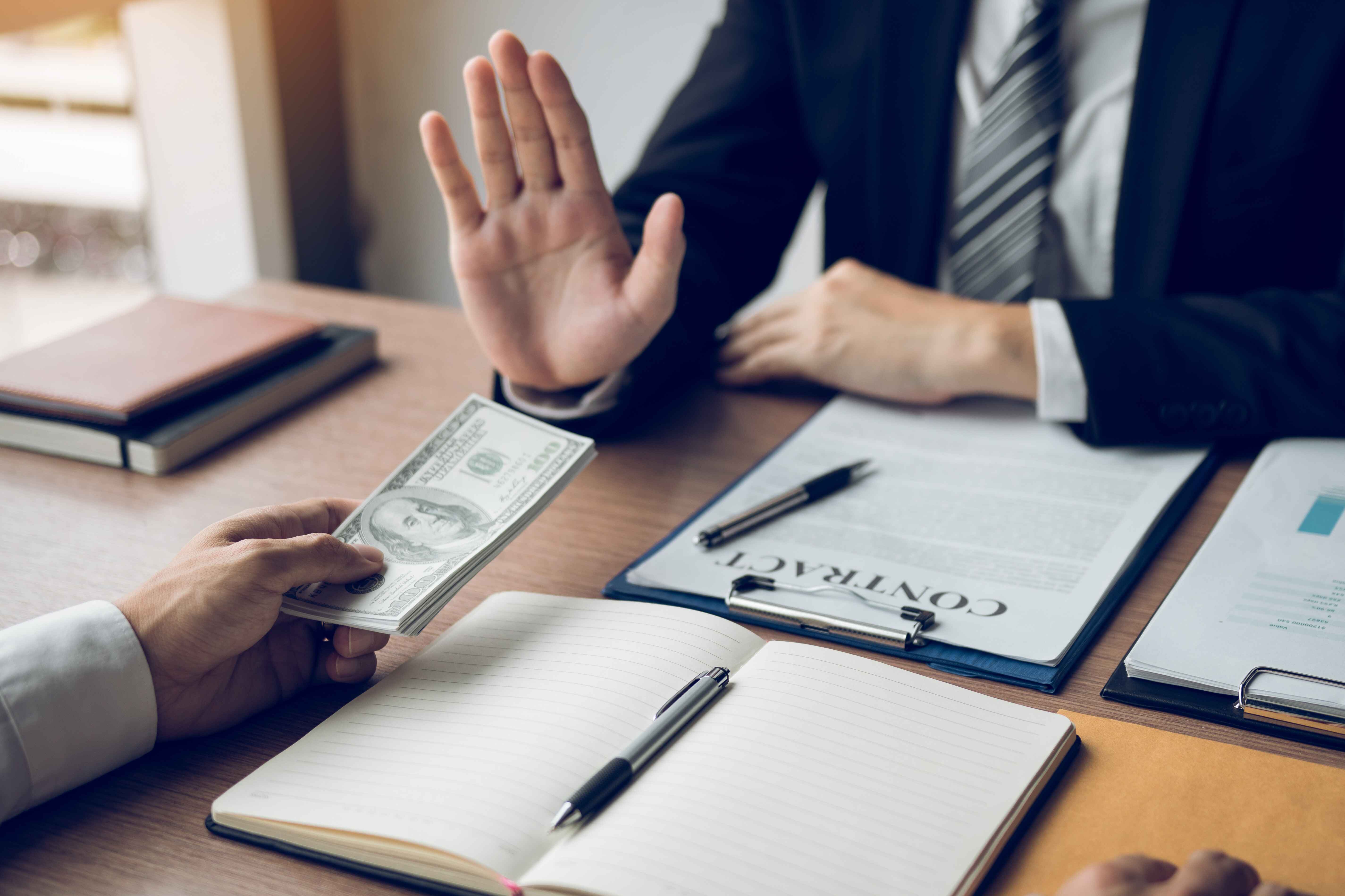 vecteezy_business-person-refusing-bribe-given-money-by-partner-with_5410814%20%281%29.jpg